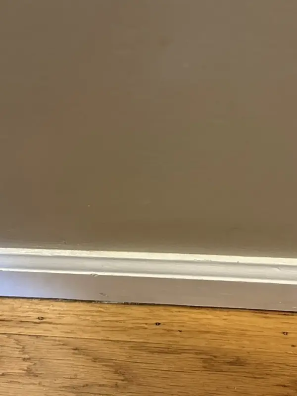 The same baseboard white and clean after deep cleaning