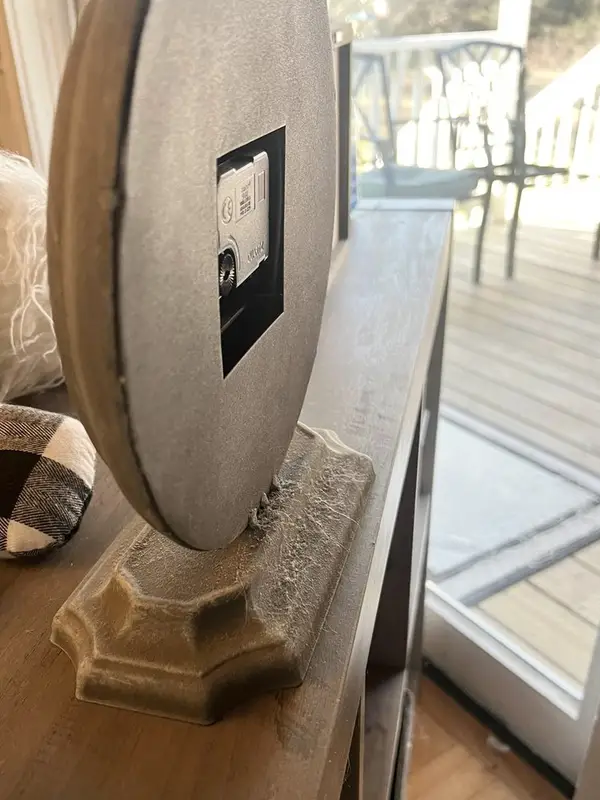 Dusty carved base of a round mirror before deep cleaning