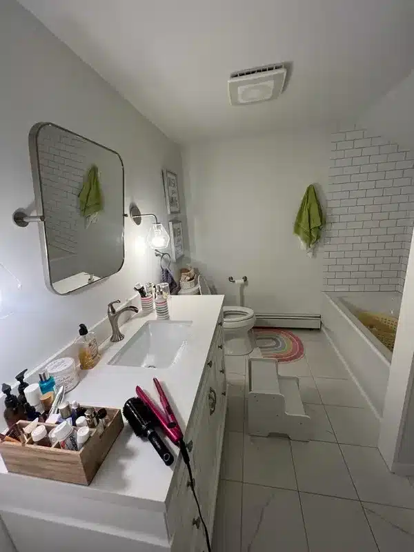 Bathroom vanity covered in toiletries and hair tools before cleaning, Glastonbury, CT