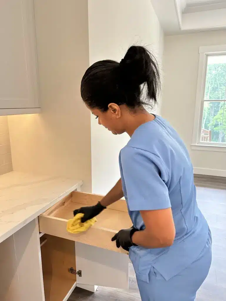 A Family Cleaners team member wiping the inside of a new drawer in a bathroom vanity