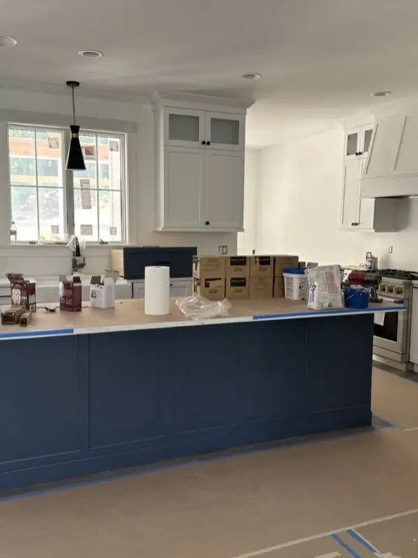 New kitchen island covered in supplies and boxes, with paper on the floor