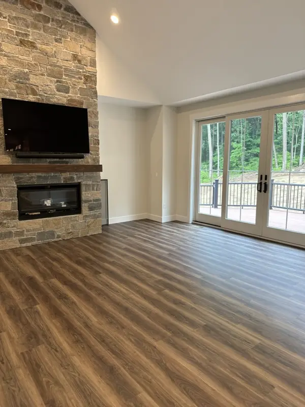 The same living room finished, with clean wood floors and the fireplace wall