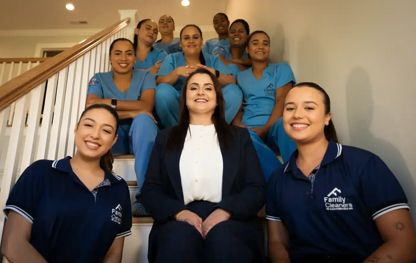 Family Cleaners team members seated on a staircase with CEO Caroline Compiani